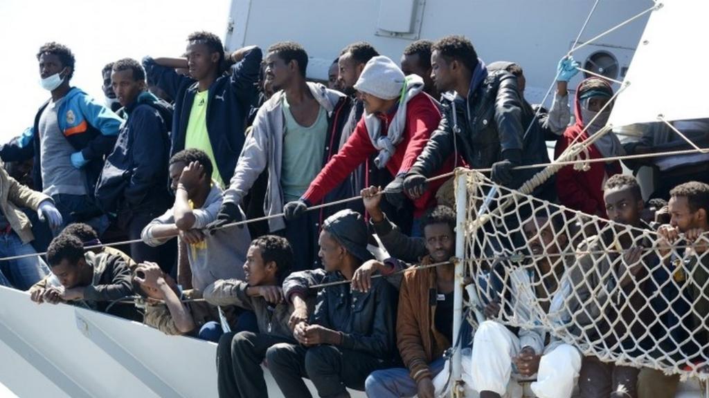 Rescued migrants wait to disembark in Italy