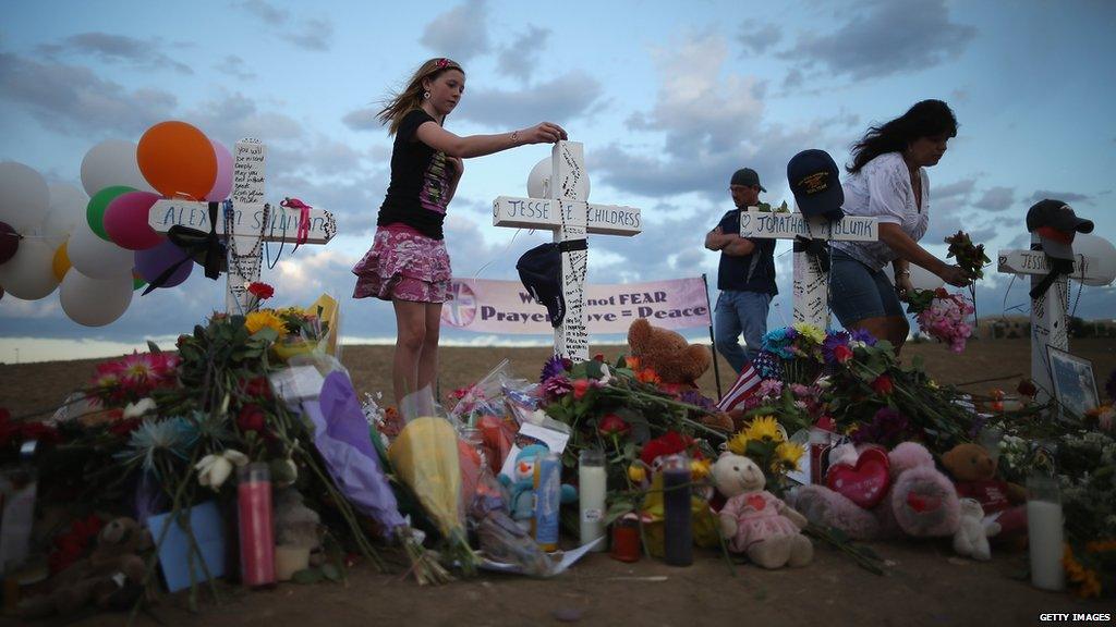People tend to a memorial near the cinema