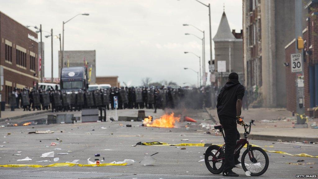 Man on a bike in front of a police line