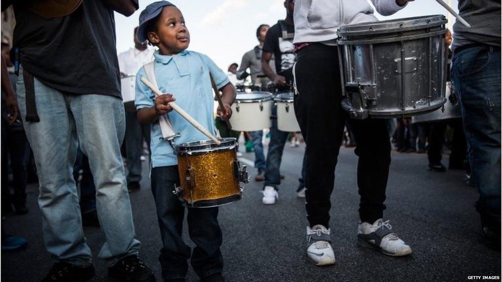 A boy plays a drum in a musical protest