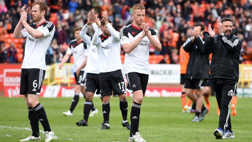 The Aberdeen players and management salute the fans at the end of the game at Tannadice