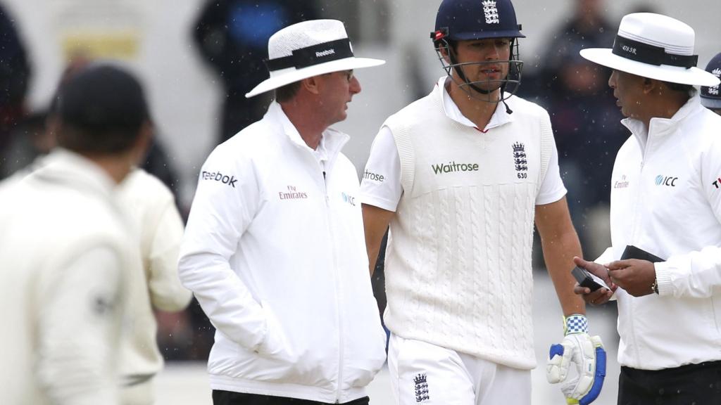 Alastair Cook talks to the umpires