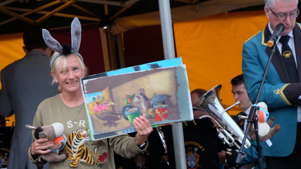 Jill Newton holding her book in front of the band