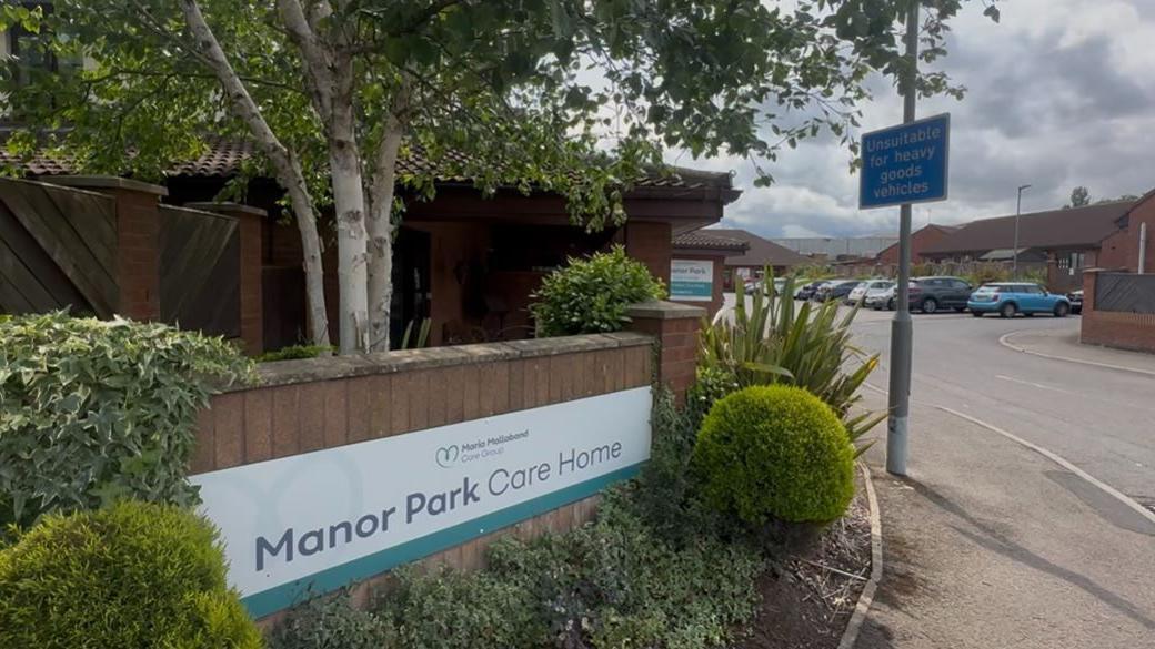 A close-up of the sign for Manor Park Care Home.