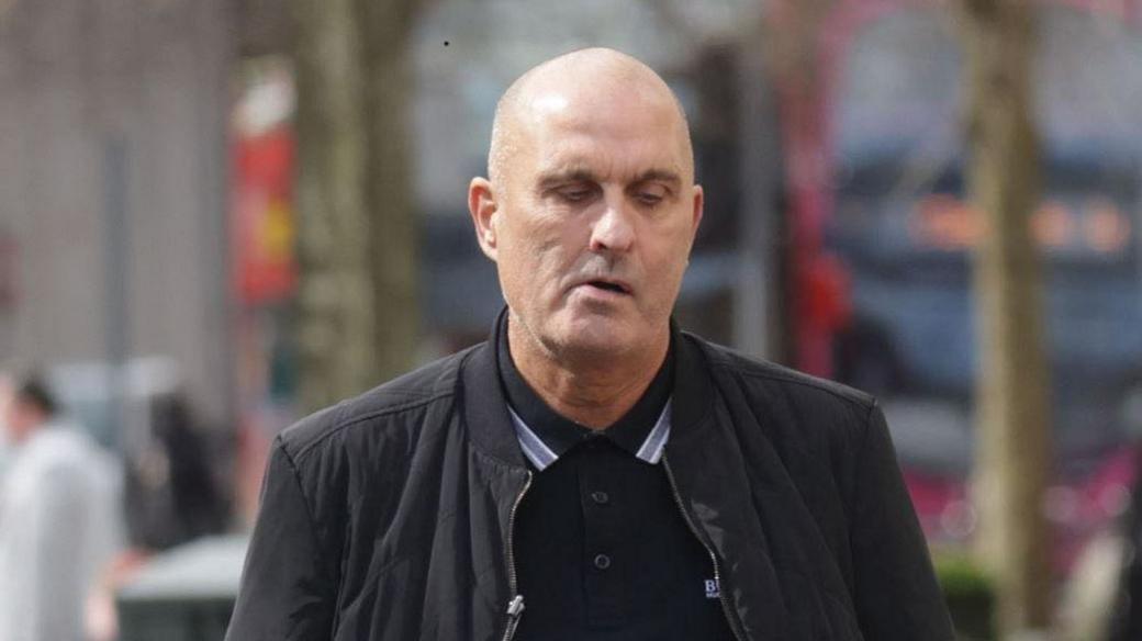 Derek George Lammey, a man wearing a black jacket, with black polo shirt.