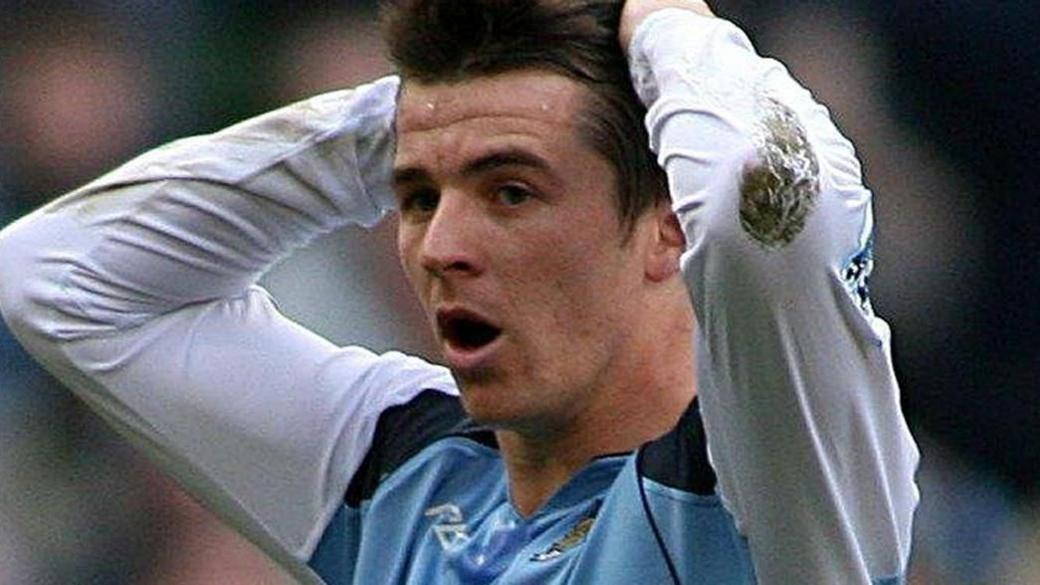 Joey Barton with brown hair playing for Manchester City in 2007 holding his hands up to his head after missing a chance during the match.