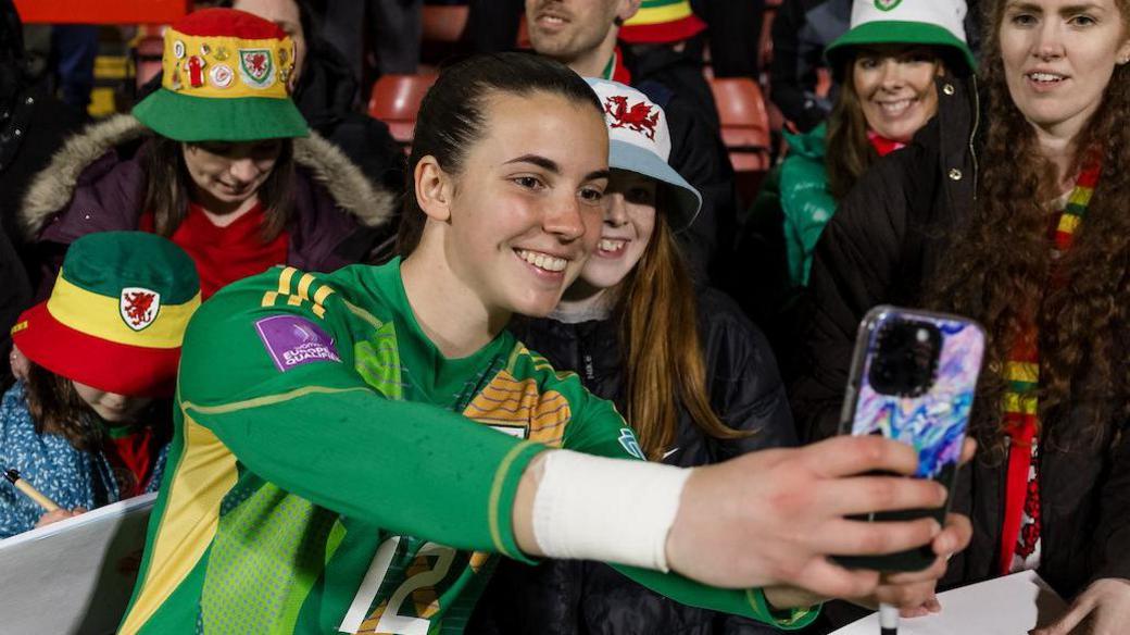 Olivia Clark doing selfie with Wales fans