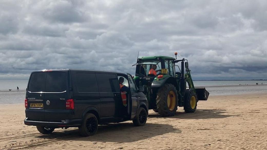 Van being towed off beach