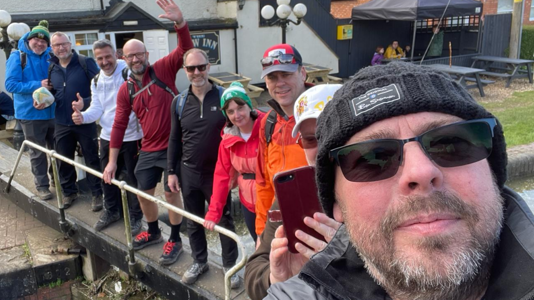 A group of walkers posing for a photo by a canal