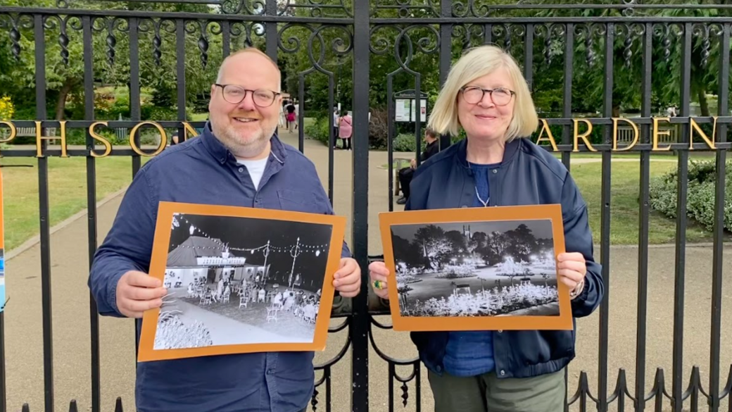 David Clargo and Carole Sleight of Whittle Productions holding photos from the 1950s festival while standing by the gates of Jephson Gardens