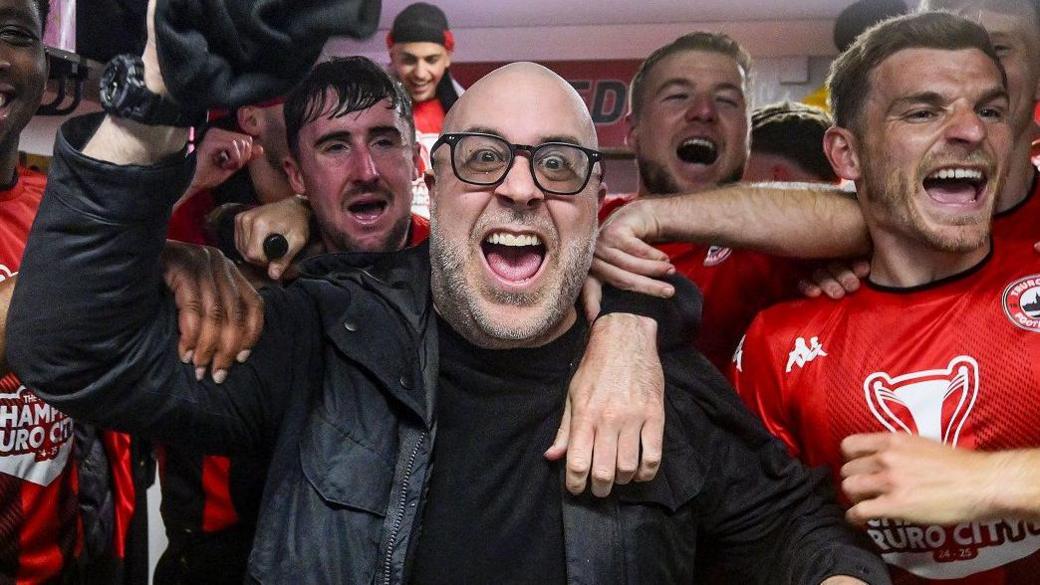 Eric Perez celebrates in the changing rooms with his team after Truro City won National League South last season