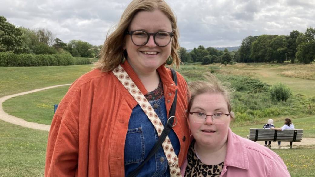 Sarah and Lucy standing together in a park in Cheltenham; Sarah with her arm around Lucy