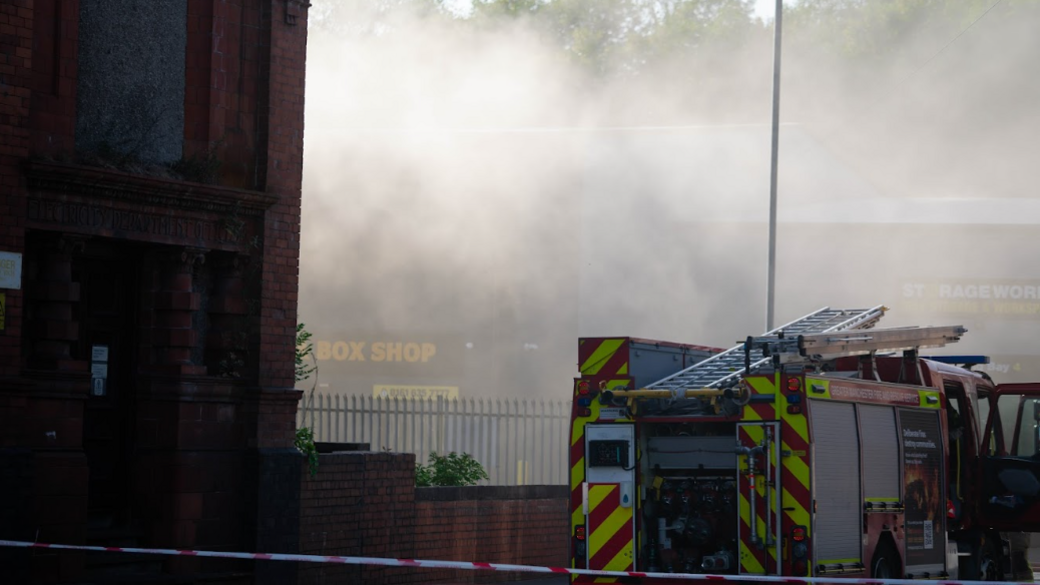 Smoke surrounds a fire engine at the scene of the blaze