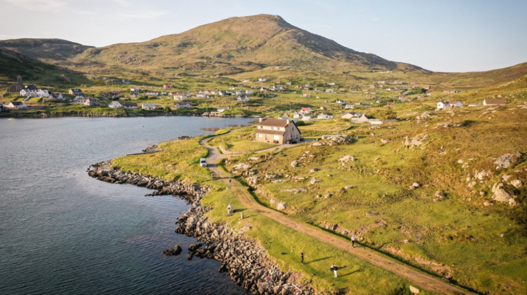 Properties spread across the Isle of Barra, Outer Hebrides, with water in the foreground