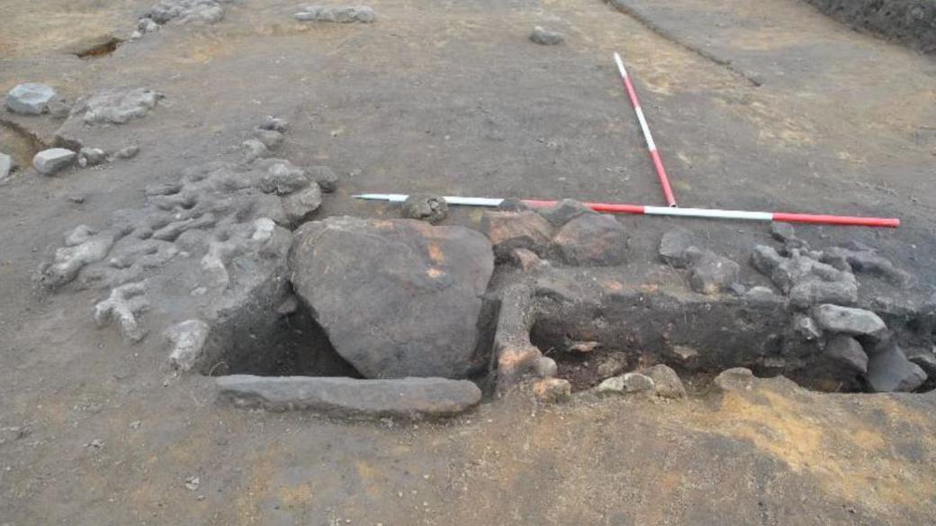 A picture of an Anglo-Saxon oven which is a hole in the ground with stones over it 