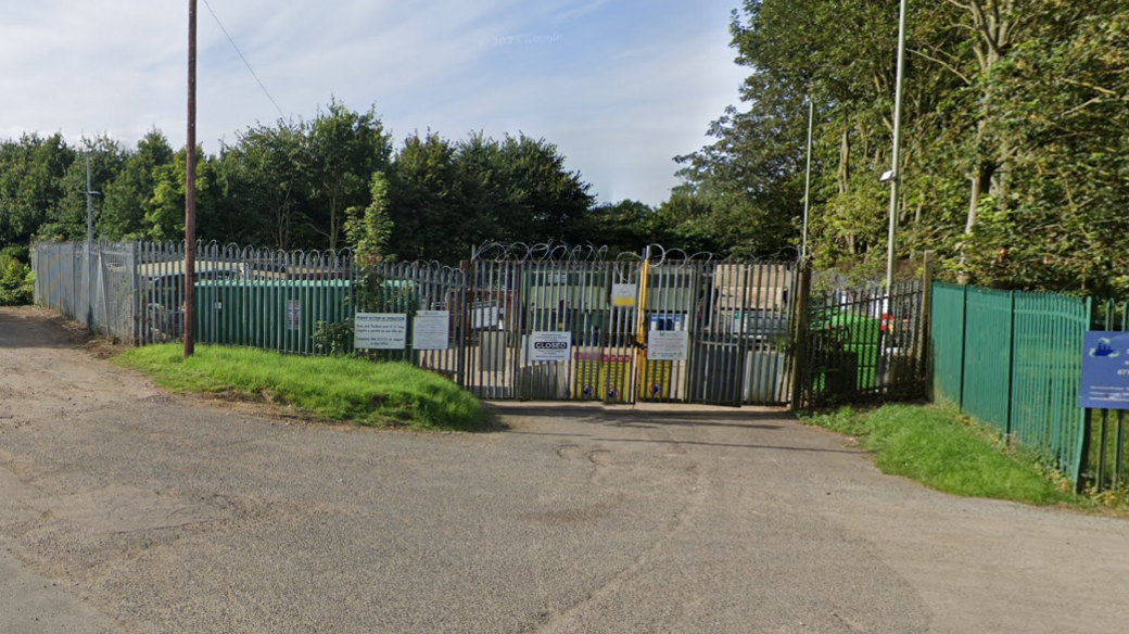 Metal fencing surrounding a household waste site with the gates shut.