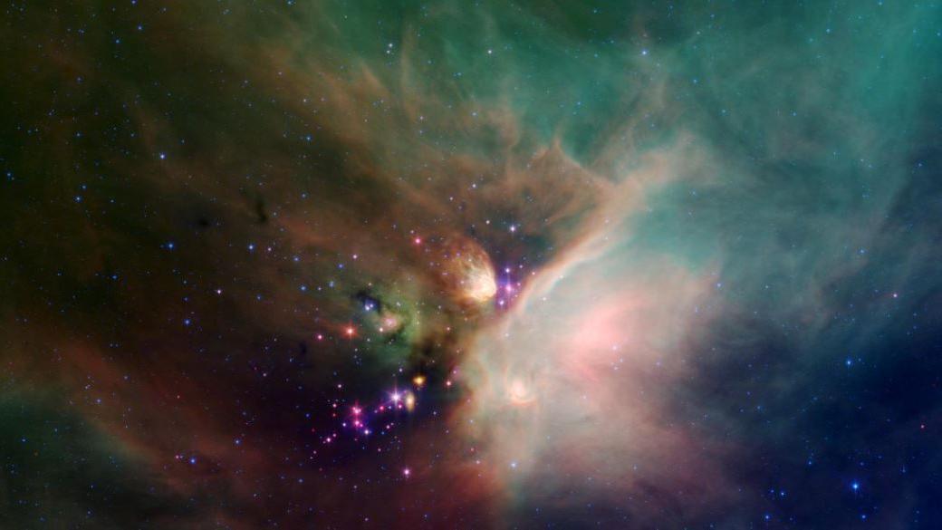 Space image of multi-coloured clouds image with small flashes of bright light, showing Rho Ophiuchi, a multiple star system containing collections of cold gas and dust where stars and planets can form. 