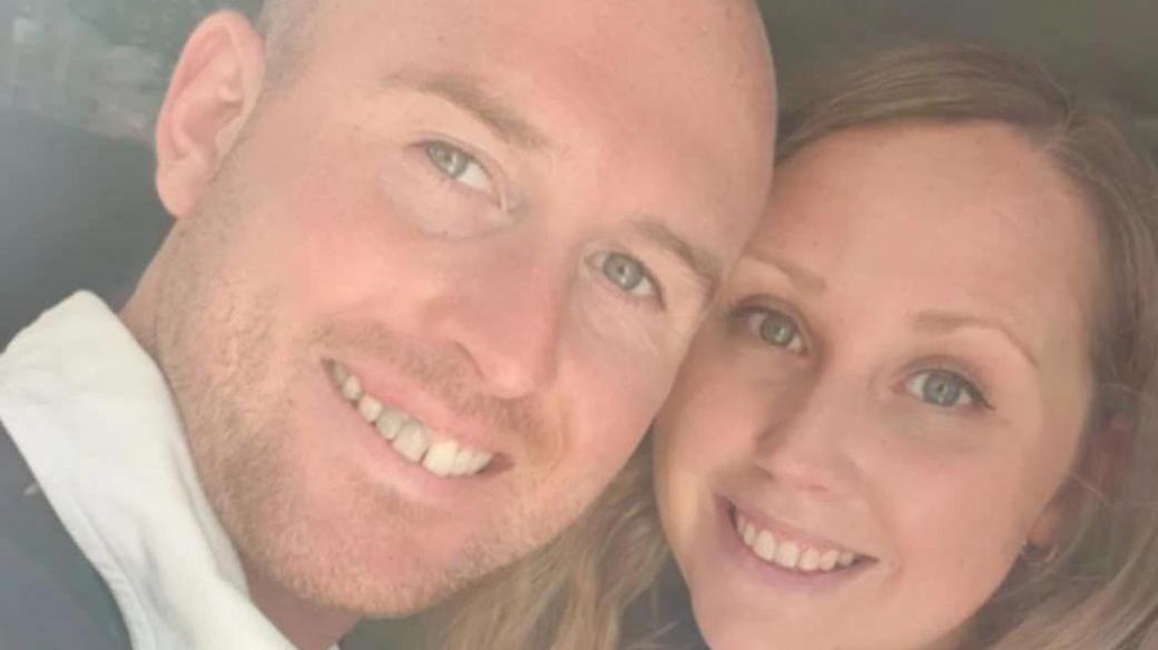 A selfie of Josh and Hannah. Hannah has long light brown hair and Josh has a shaved head and short stubble. 