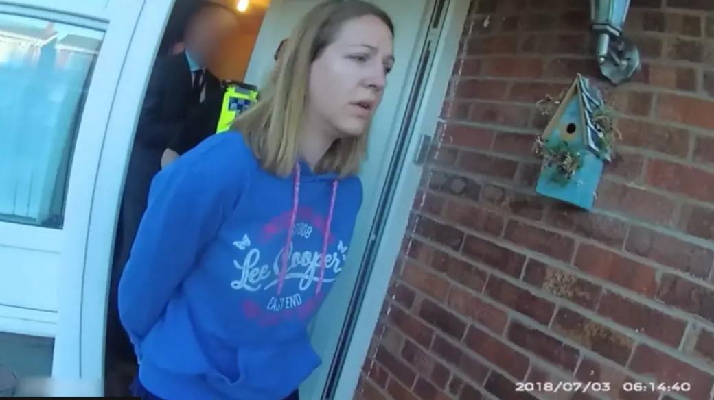 Lucy Letby, with long straight hair and a blue hoodie, is led from her front door in handcuffs