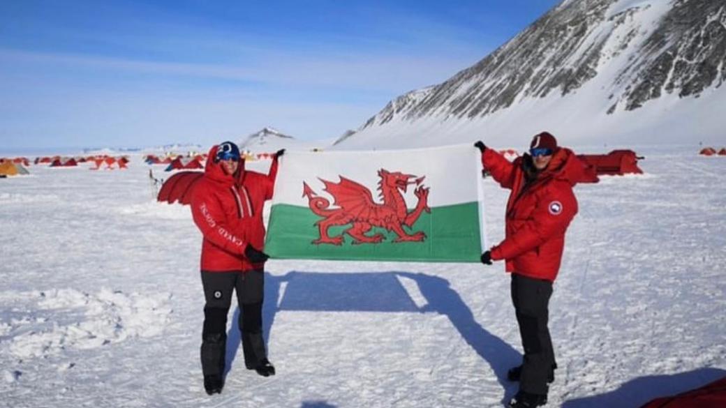 Georgina Gilbert and Rebecca Openshaw-Rowe holding a Welsh flag in Antarctica 