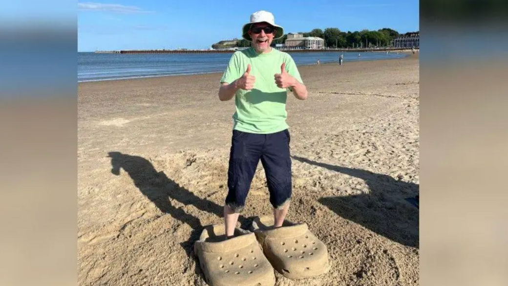 Mark in a giant pair of sand crocs.