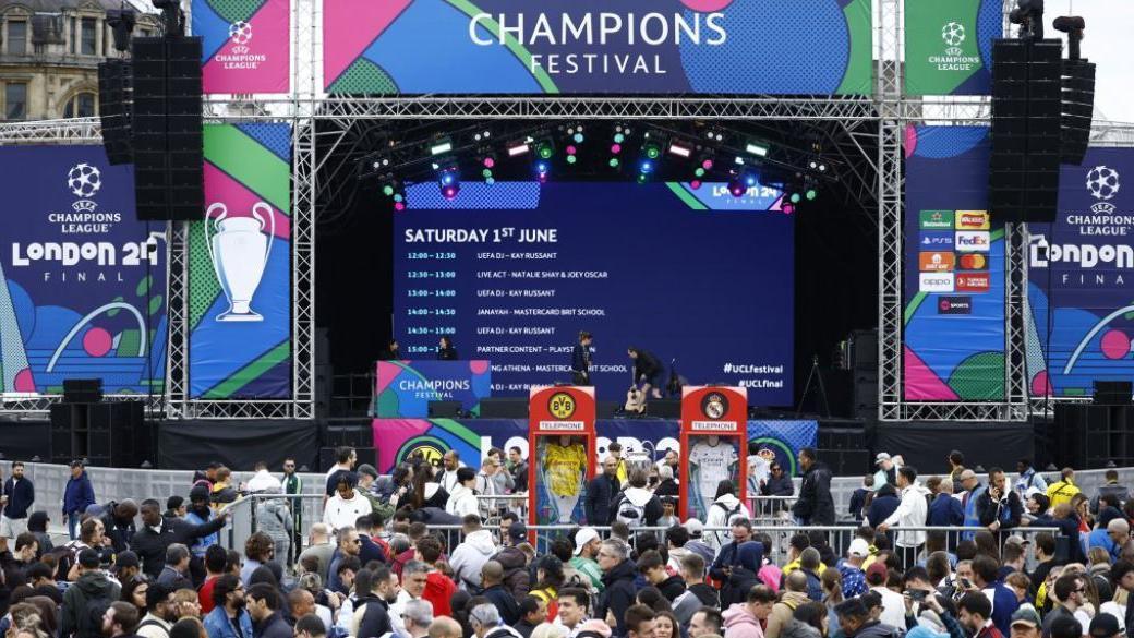 Crowds walk in front of a stage at the football festival in Trafalgar Square