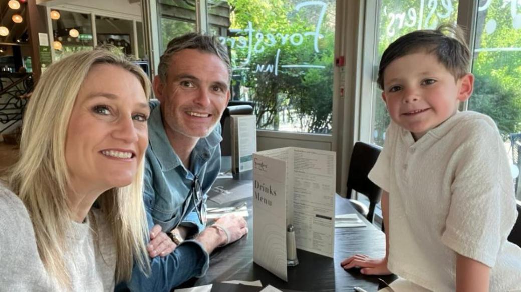 Roxie Westwood with her husband and son smiling around a table