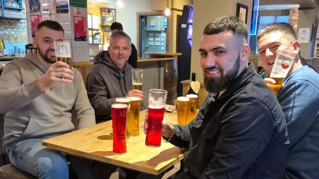 A table of men with some beers and ciders on the go