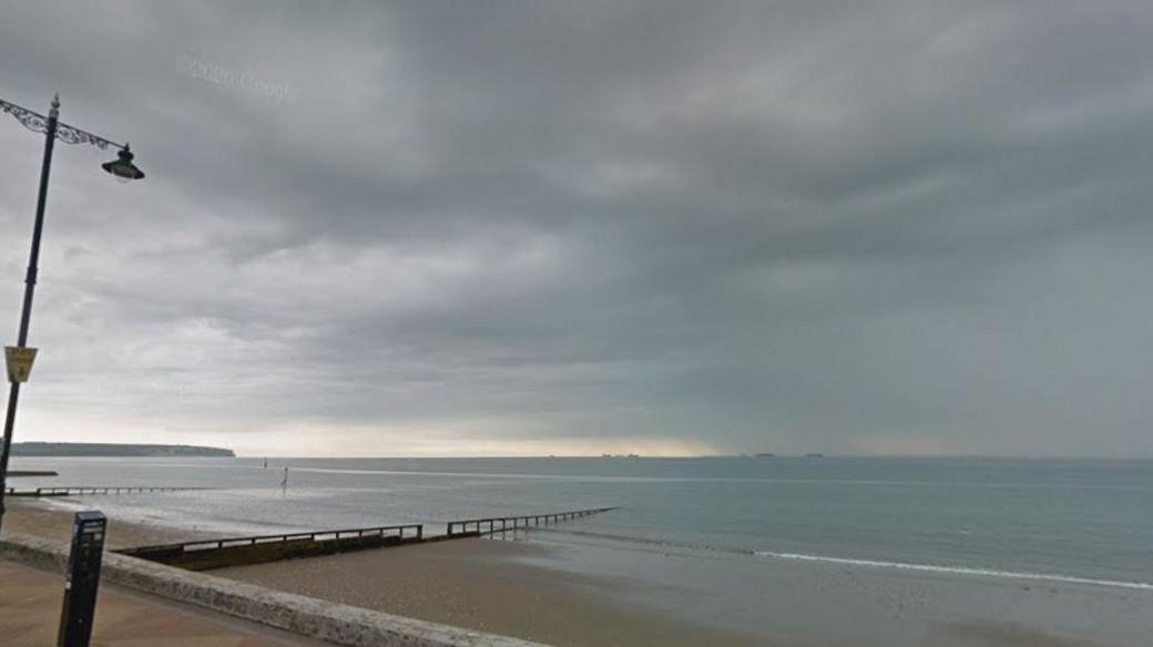 A section of the beach in Shanklin. There is a lamppost to the left of the frame and a small part of the pavement can be seen, with a small section of pebbled beach leading into the sea.