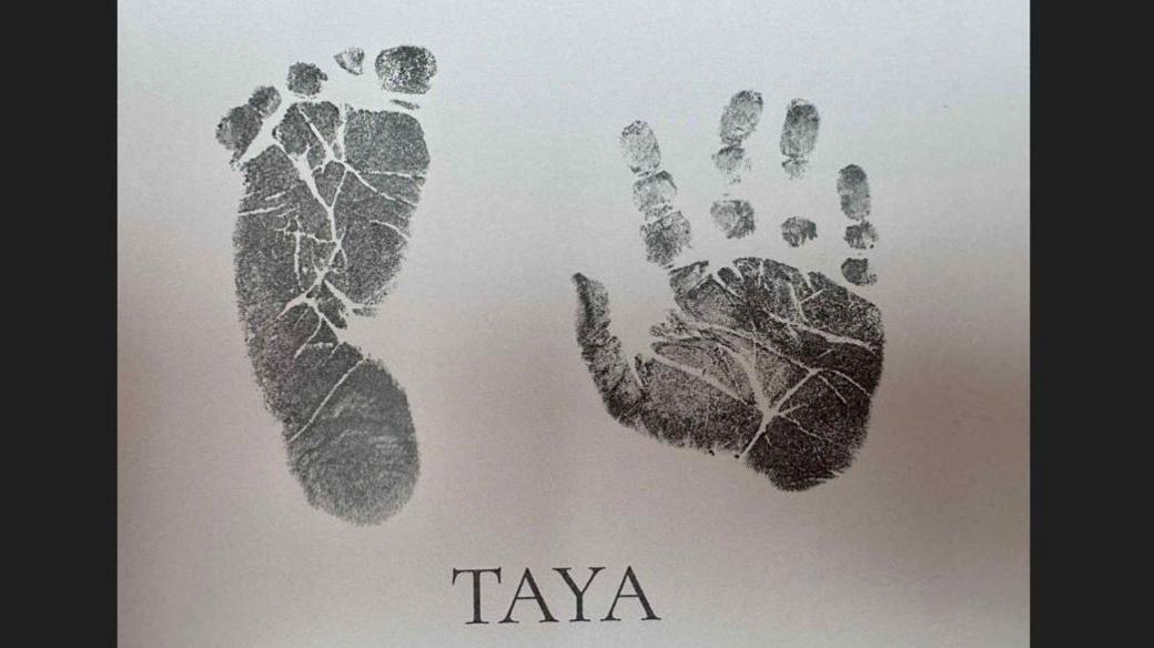 A baby handprint and footprint with the name 'TAYA' written underneath.