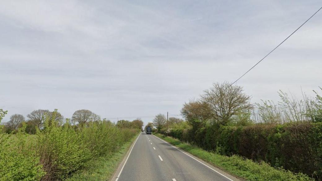 The A361 with green hedges and verges on both sides.