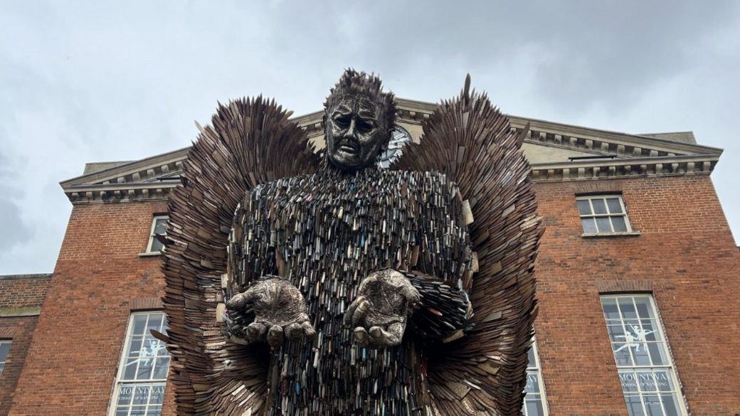 "The Knife Angel" outside the Market House in Taunton. It is a large statue made entirely of knives, and has large wings and is holding its hands out in front of itself