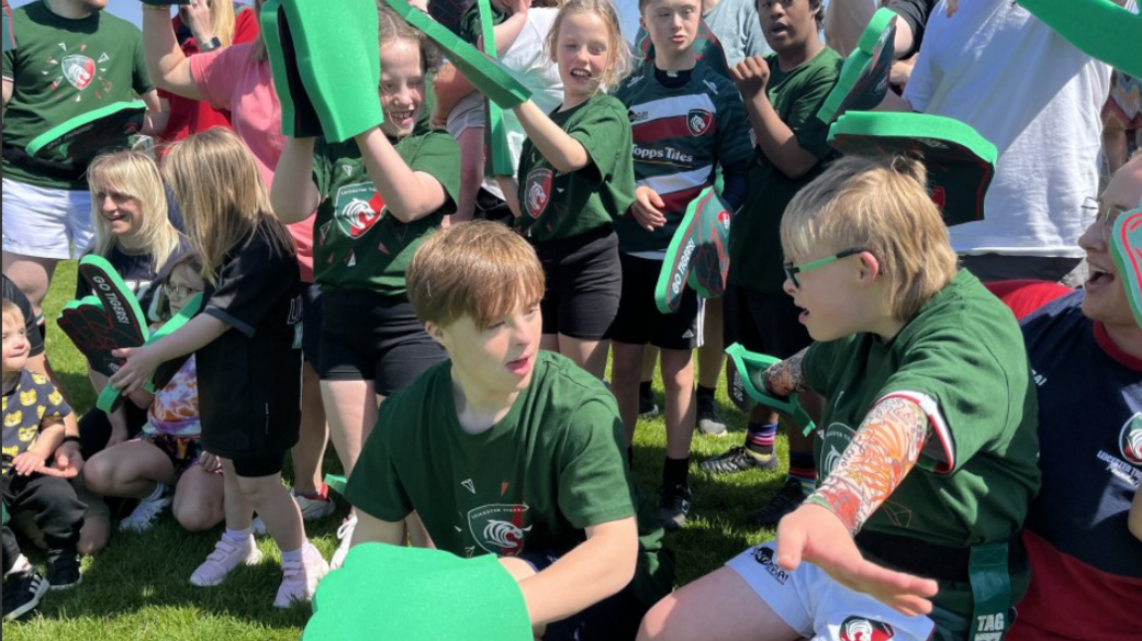 Down's syndrome players gather together wearing big foam fingers 