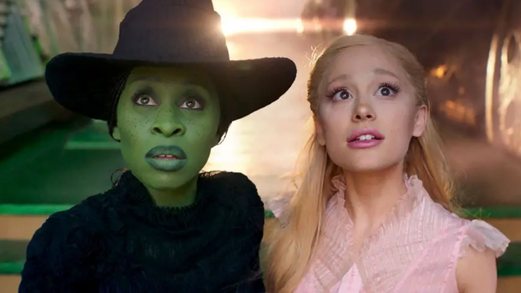 Cynthia Erivo is pictured with a green face and witch's hat, next to Ariana Grande, who has a pink dress on and blond hair