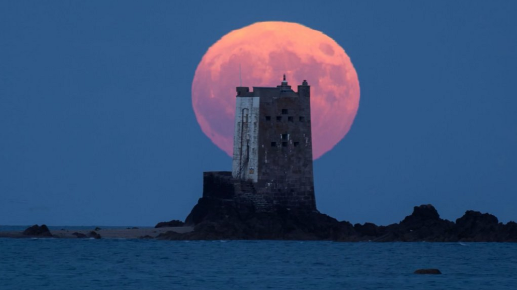 The Strawberry Moon rises behind Seymour Tower, Jersey