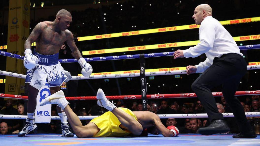 Conor Benn stands next to Chris Eubank Jr who is face down on the canvas
