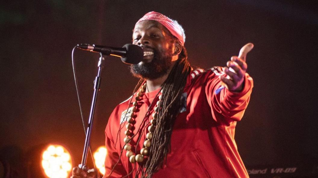 Singer Da Fuchaman in a red top singing into a microphone