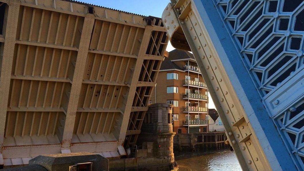 A close up photo of Haven Bridge, with both sides raised for boats to travel underneath.