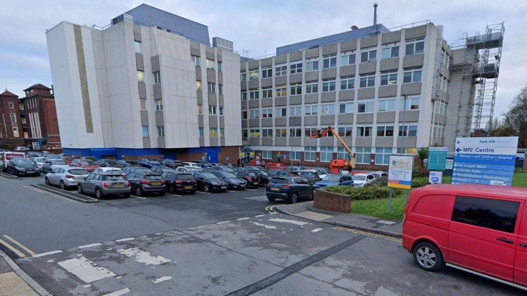 Doncaster Women and Children's Hospital. Pictured is a large concrete building with a car park and a faded zebra crossing in the foreground