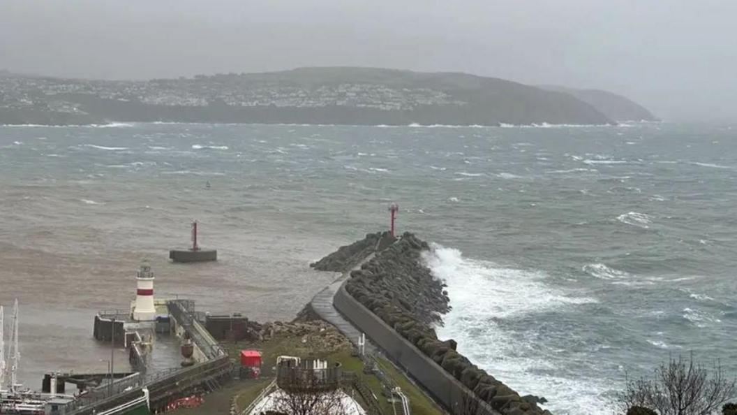 A grey and blustery view of Douglas Bay with choppy waters, with Onchan Head in the distance.