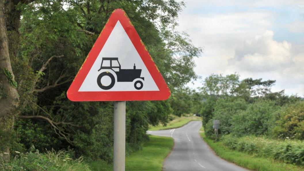 arwydd tractor ar y ffordd