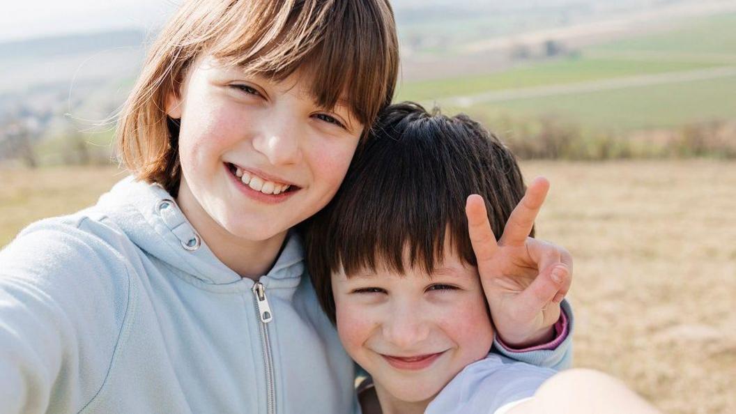 Girl posing with brother.