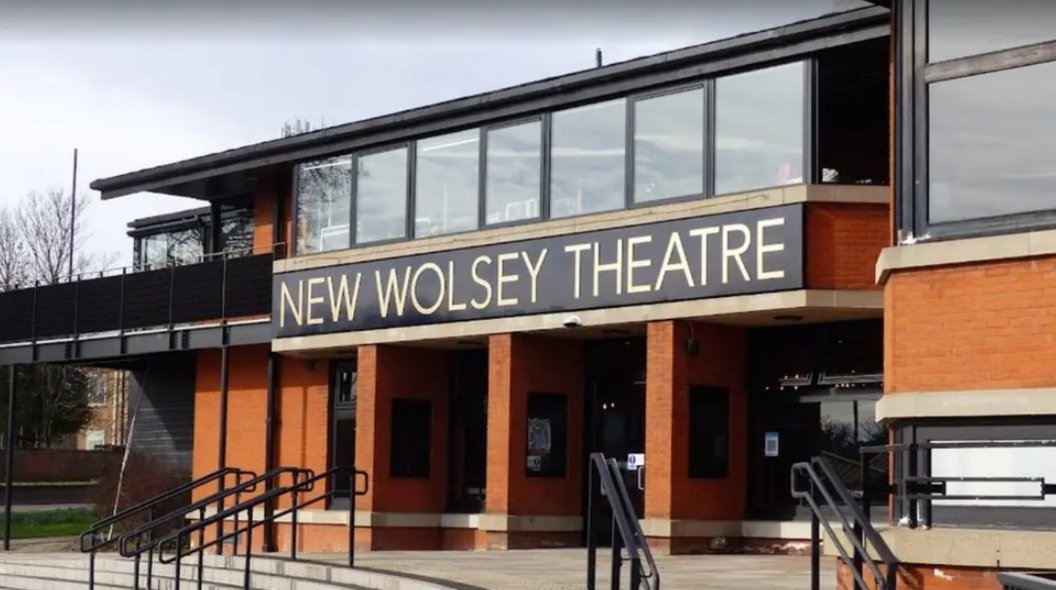 The entrance to the New Wolsey Theatre in Ipswich. There are steps and railings leading up to the entrance. It is a modern two-storey building