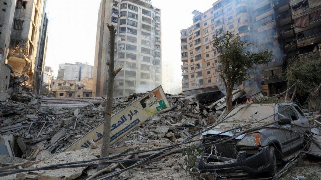 Damaged buildings and a destroyed vehicle following an Israeli air strike on Beirut, Lebanon. Photo: 27 October 2024