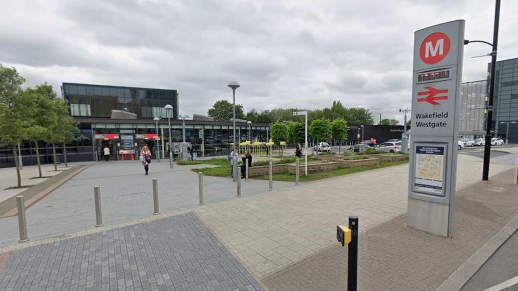 Wakefield Westgate station from outside, showing the station sign and walkway in front