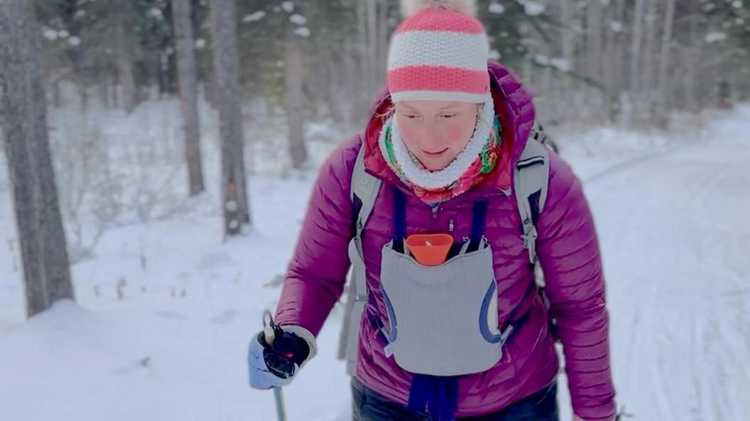 Pavlina cross country skiing with hot water bottle on her chest