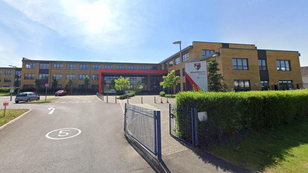 Winterbourne Academy in South Gloucestershire. It is a brown brick building with a red porch. 