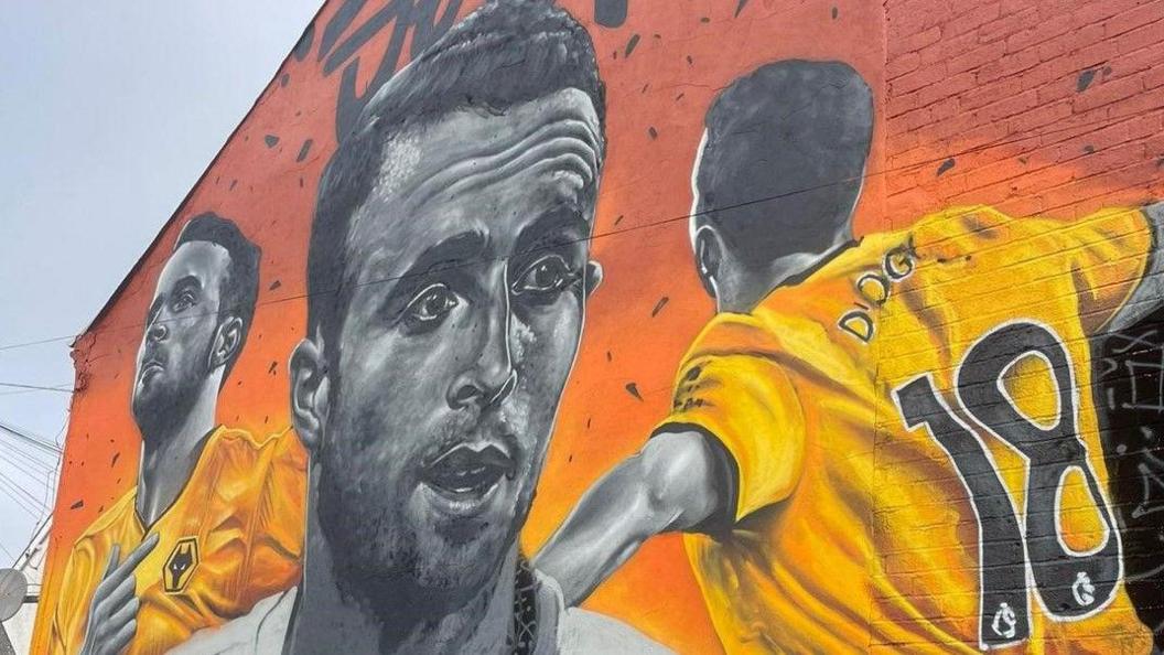 A mural depicting Diogo Jota in black and white in the middle and the player wearing Wolves' strip to the left and right. 