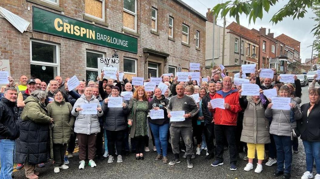 Protesters pose for a photograph outside the Crispin Arms