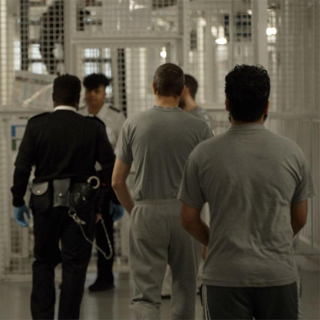 Prisoners and guards walking around a wing of HMP Pentonville.